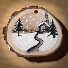 a piece of wood with a house and trees painted on it