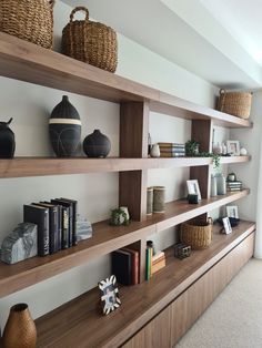 some shelves with baskets and books on them in a room that has carpeted flooring