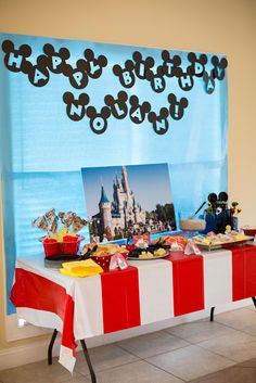 the table is set up with mickey mouse pictures and other food items for an event