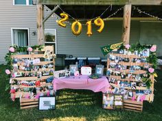 a table topped with pictures and balloons in front of a house