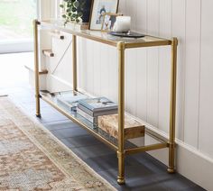 a gold console table with books on it