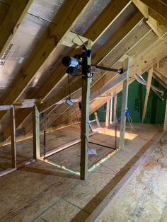 an unfinished attic with wooden floors and exposed rafters on the ceiling, including ladders