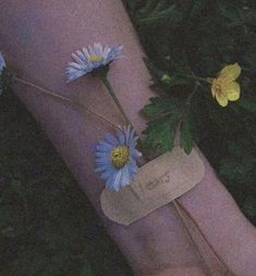 a person's arm with blue flowers on it and a tag attached to the wrist