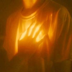 a blurry image of a person holding their hand up to the light coming from behind