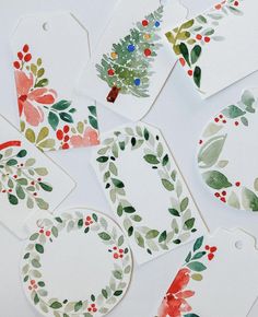 christmas gift tags with watercolor leaves and holly wreaths on them, surrounded by red berries