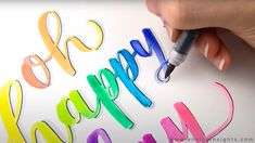 a person writing happy birthday on a piece of paper with colored crayons and a marker