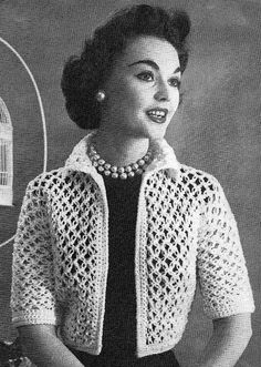 an old photo of a woman wearing a crochet jacket and pearls in front of a birdcage