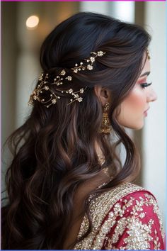 a woman with long dark hair wearing a gold headpiece and earrings on her head