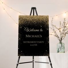 a black and gold birthday sign sitting on top of a easel next to a vase filled with flowers