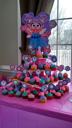 a purple table topped with lots of cupcakes