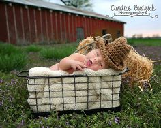 a baby is laying in a basket with hay