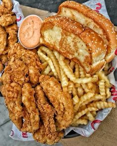 fried chicken, french fries and coleslaw on a paper plate with dipping sauce