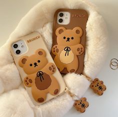 two brown teddy bears are sitting next to each other on a white fur covered surface