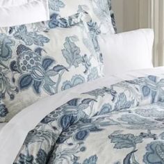 a bed with blue and white comforters on top of it