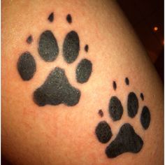 a close up of a person's arm with a tattoo of an animal paw