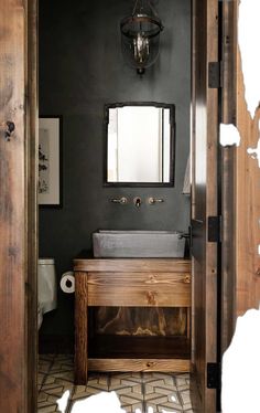 a bathroom with a sink, mirror and wooden cabinet in it's center area