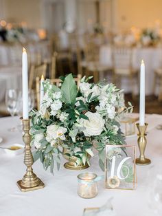 a centerpiece with flowers and candles is displayed on a table at a wedding reception