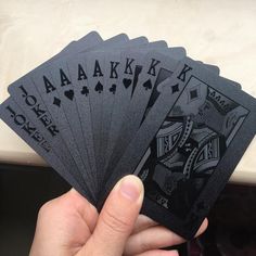 a person holding four playing cards in their hand