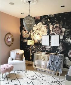 a baby's room decorated in black and white with floral wallpaper