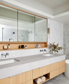 a bathroom with two sinks, mirrors and a bathtub in the middle of it