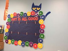 a bulletin board that says art is all good with a cat sitting on top of it