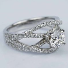 a white gold ring with an oval cut diamond surrounded by pave diamonds