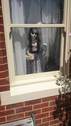 a creepy doll is sitting in the window