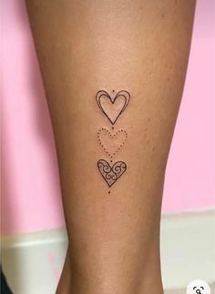 a woman's leg with two hearts tattoo on the left side of her calf