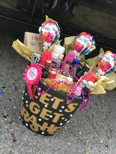 a bucket filled with lots of items sitting on the ground