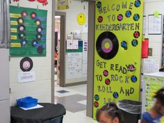 children are sitting at desks in a classroom with posters on the wall behind them