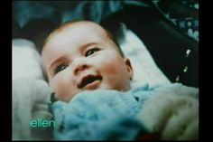 a baby in a stroller looking up at the camera with his hand on it's chest