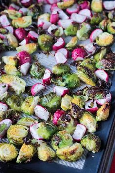 roasted brussel sprouts and radishes on a baking sheet ready to be cooked