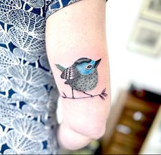 a small bird tattoo on the arm