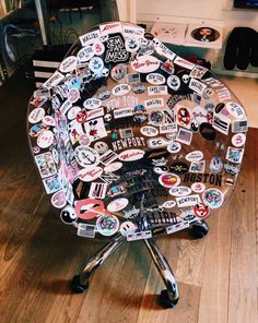 an office chair covered in lots of stickers and magnets sitting on top of a hard wood floor