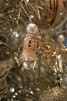 a christmas tree decorated with musical notes and ornaments in gold, silver and white colors