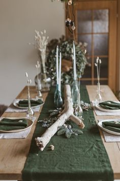 the table is set with green napkins and place settings