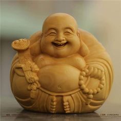 a laughing buddha statue sitting on top of a table