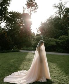 the back of a bride's dress as she stands in grass