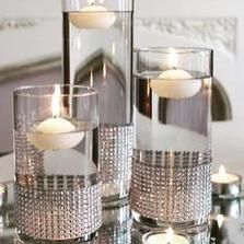 candles are lit in glass vases on a table