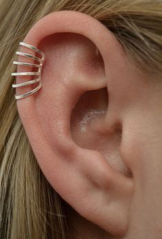 a woman's ear is shown with three thin bars attached to it