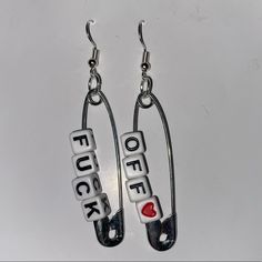 two earrings with words on them are hanging from hooks