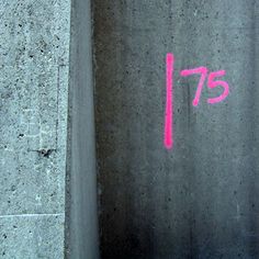 graffiti on the side of a concrete wall that reads'757'in pink