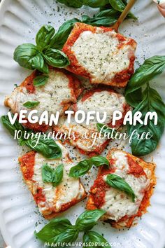 vegan tofu parm on a white plate with basil leaves