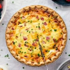 a pizza sitting on top of a table next to other plates and bowls filled with food