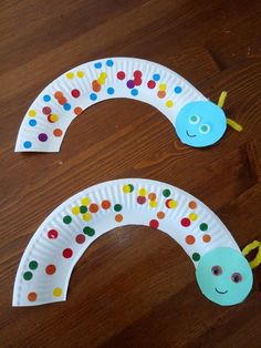 two paper plates with different colored dots on them, one is shaped like a caterpillar