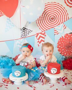 two babies sitting next to each other in front of cake