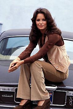 a woman sitting on the hood of a car