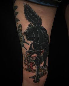 a black and grey tattoo on the leg of a person with an owl, bird and snake