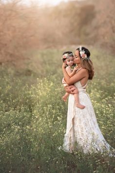 a mother and her two daughters in a field at sunset with the sun shining on them