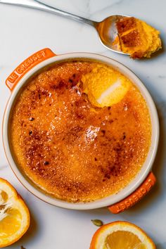 a white bowl filled with food next to sliced oranges